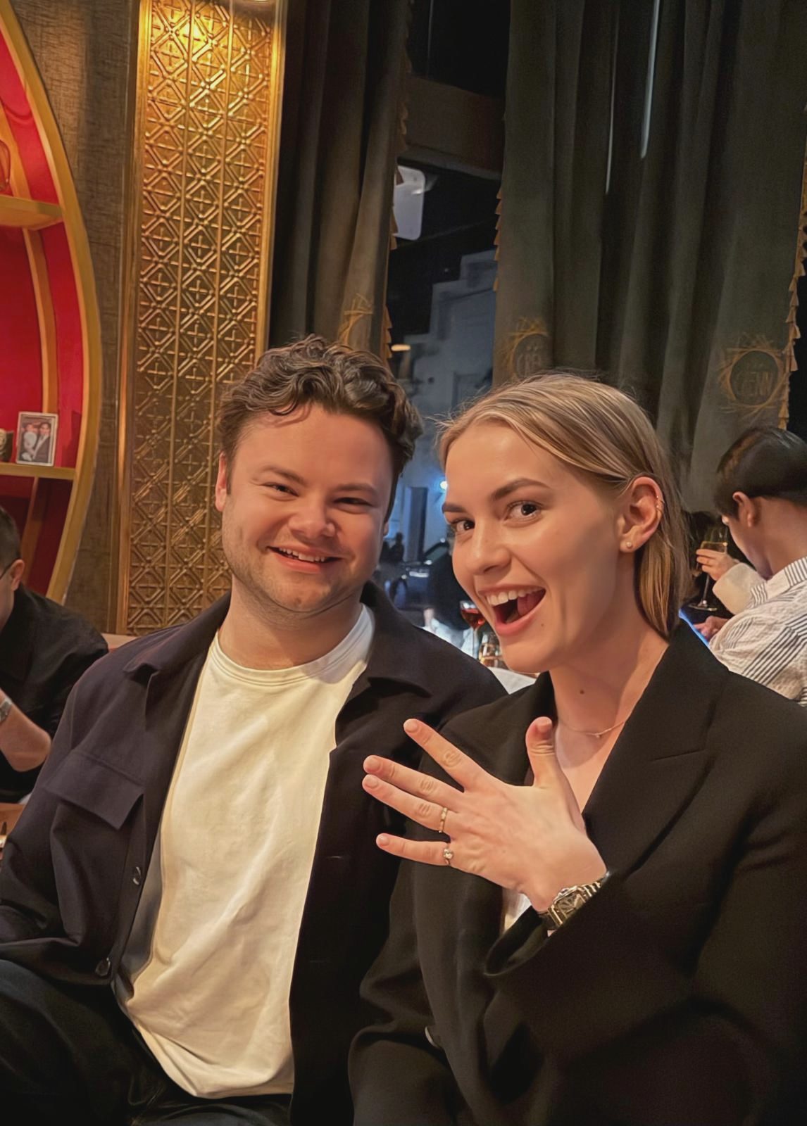 Alexandra showing her ring, David laughing next to her