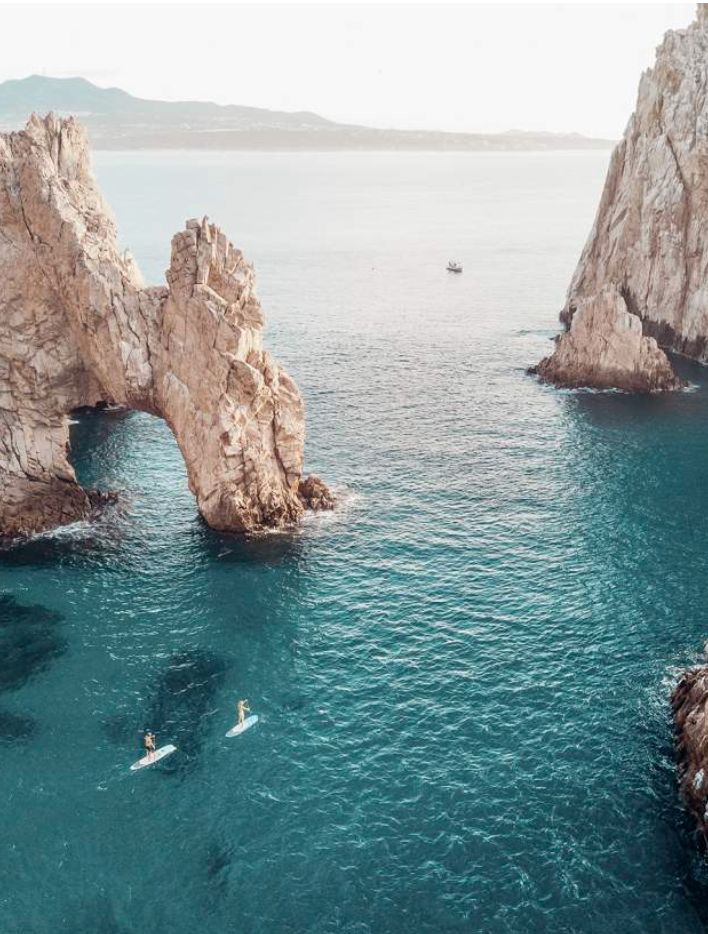 The Arch at Land's End, with two paddleboarders in the water below