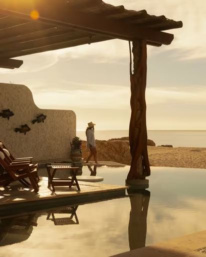 A shaded terrace and plunge pool at golden hour, looking out to the beach